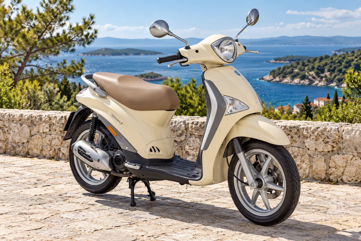 Cream Piaggio Liberty scooter by the sea